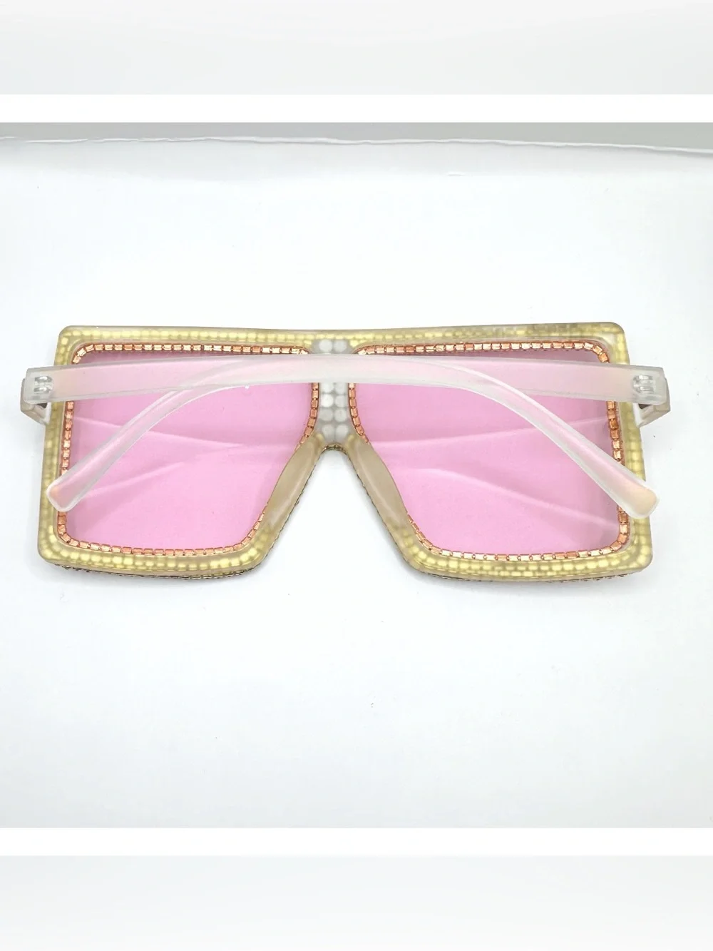 Oversized square flat-top sunglasses feature translucent pink lenses and frames